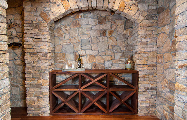 Inspiration for a mid-sized eclectic dark wood floor wine cellar remodel in New York with display racks