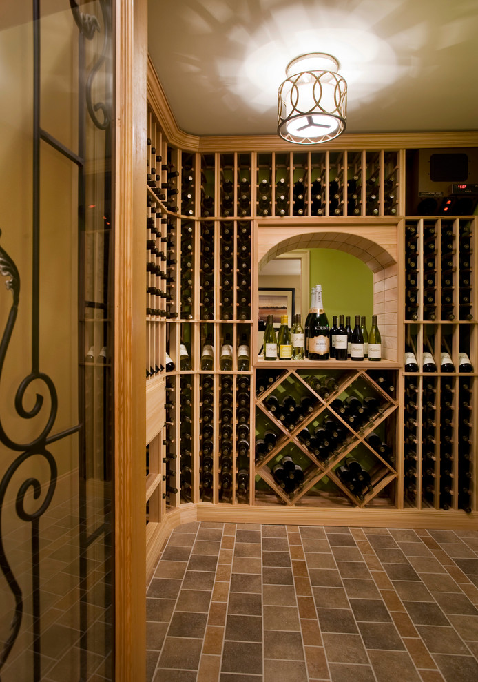 Aménagement d'une cave à vin classique de taille moyenne avec sol en béton ciré, des casiers et un sol beige.