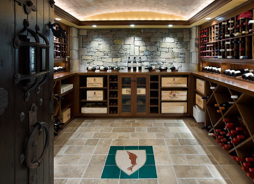 This is an example of a large rustic wine cellar in Boston with limestone flooring, cube storage and beige floors.