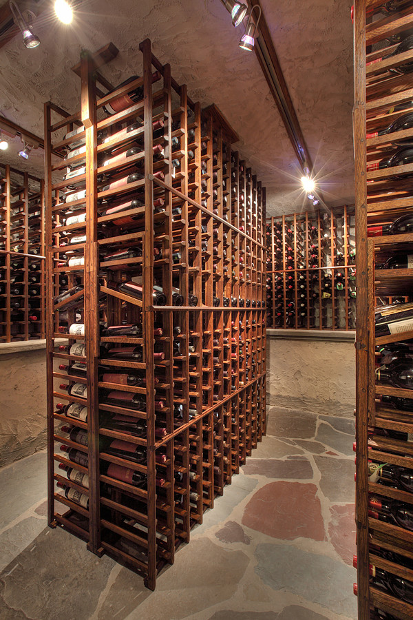 Inspiration for a huge rustic slate floor wine cellar remodel in New York with display racks