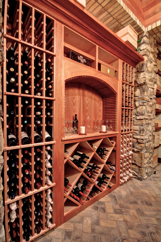 Aménagement d'une cave à vin classique de taille moyenne avec un sol en calcaire et des casiers.