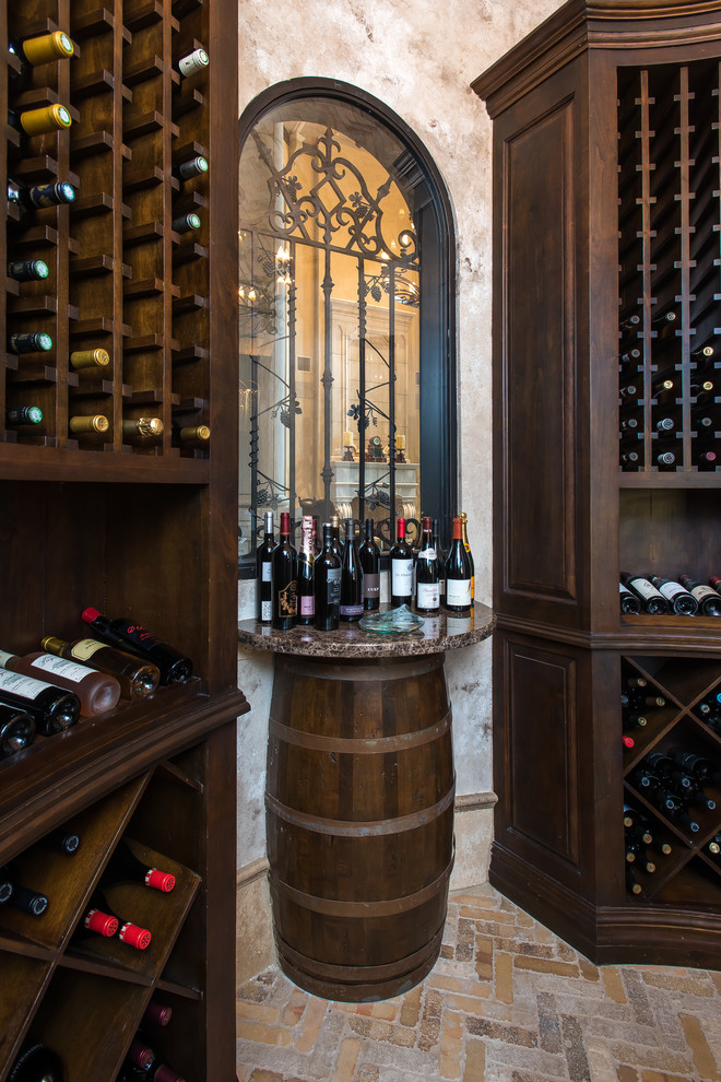 Inspiration for a large mediterranean limestone floor wine cellar remodel in Houston with storage racks