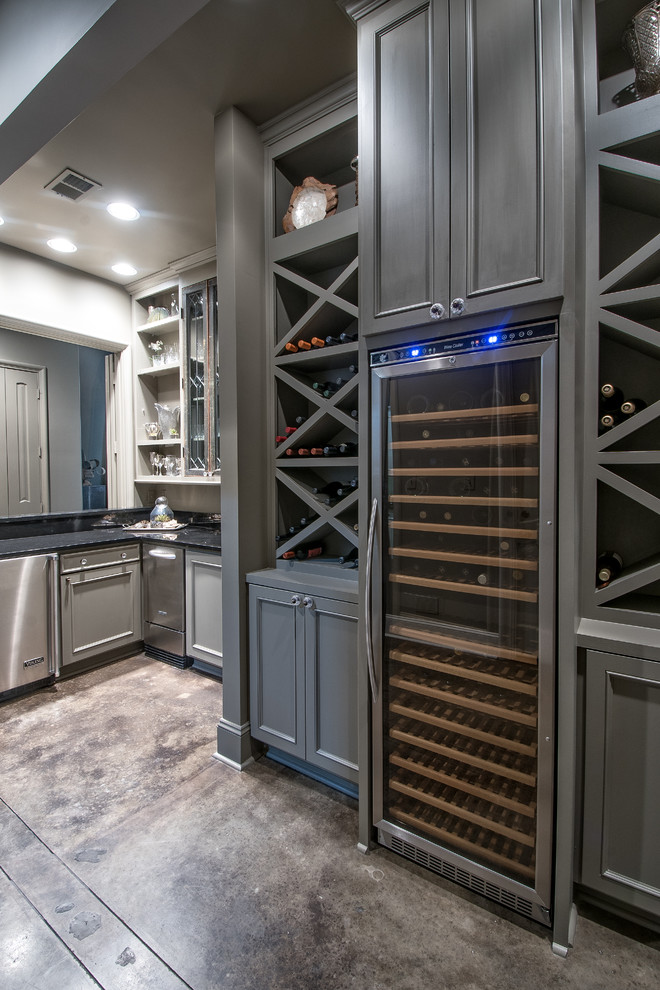 Example of a mid-sized transitional concrete floor wine cellar design in Other with storage racks