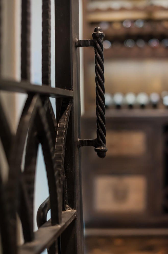 Foto på en stor vintage vinkällare, med mörkt trägolv, vinhyllor och brunt golv