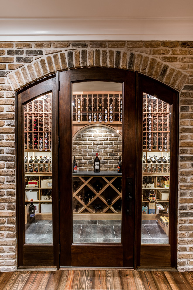 Large traditional wine cellar in DC Metro with ceramic flooring and storage racks.