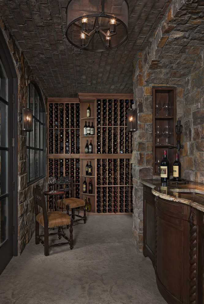 Inspiration pour une cave à vin traditionnelle avec des casiers et un sol gris.