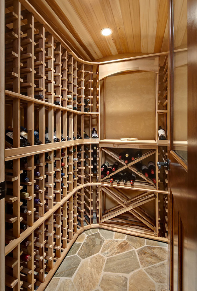Cette photo montre une petite cave à vin tendance avec tomettes au sol et des casiers.