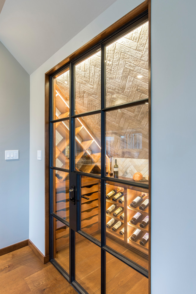 Wine cellar - mid-sized medium tone wood floor and brown floor wine cellar idea in Austin with storage racks