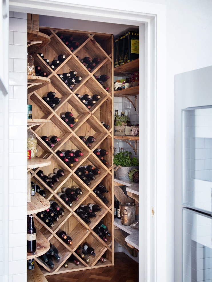 Kleiner Landhausstil Weinkeller mit dunklem Holzboden, diagonaler Lagerung und braunem Boden in London