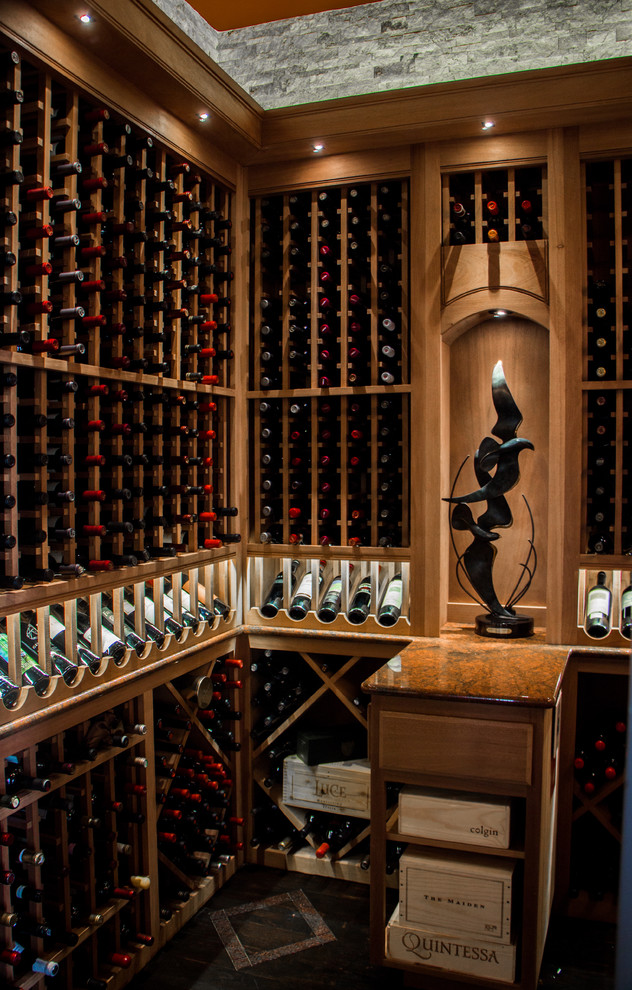 Large traditional wine cellar in Austin with dark hardwood flooring and display racks.