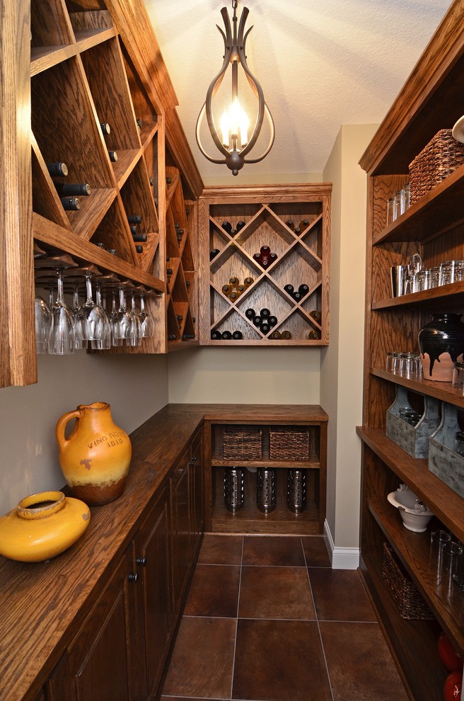 Cette photo montre une petite cave à vin chic avec des casiers losange et un sol marron.
