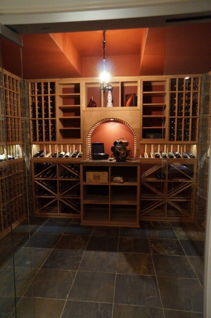 Foto på en mellanstor funkis vinkällare, med skiffergolv, vinhyllor och grått golv