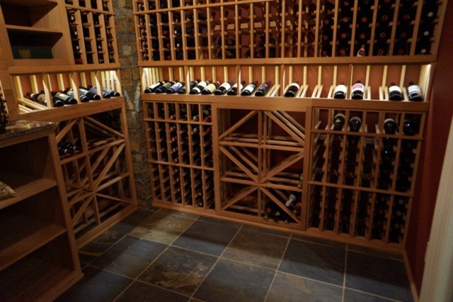 Cette photo montre une cave à vin tendance de taille moyenne avec un sol en ardoise, des casiers et un sol gris.