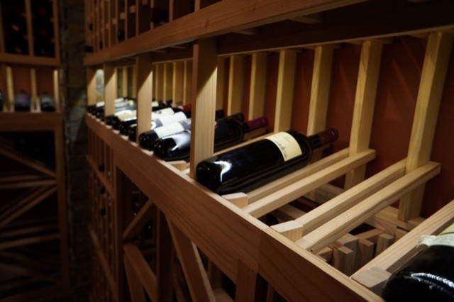 Idée de décoration pour une cave à vin design de taille moyenne avec un sol en ardoise, des casiers et un sol gris.