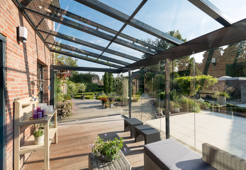 Design ideas for a medium sized traditional conservatory in Bremen with light hardwood flooring and a glass ceiling.