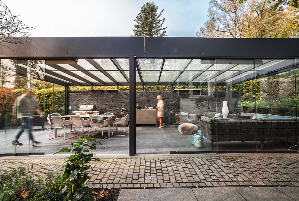 Idee per una grande veranda minimal con pavimento in cemento, nessun camino, soffitto in vetro e pavimento grigio