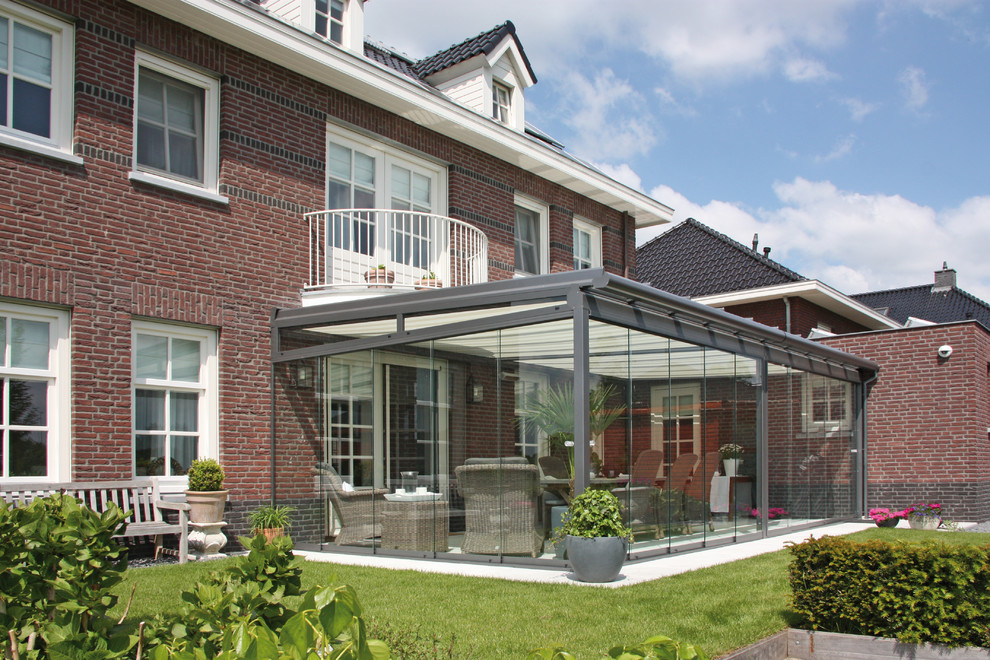 This is an example of a large contemporary conservatory in Munich with a glass ceiling and beige floors.