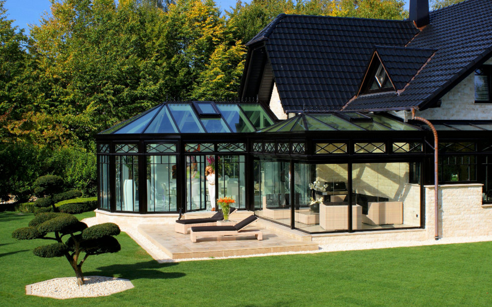 Idee per una grande veranda vittoriana con parquet chiaro, camino classico, lucernario e pavimento marrone