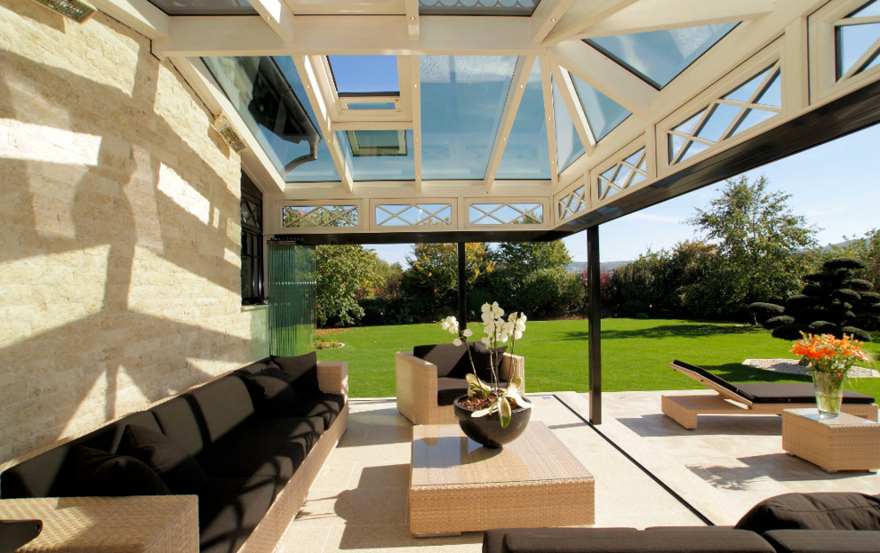 Immagine di una grande veranda vittoriana con parquet chiaro, camino classico, lucernario e pavimento marrone