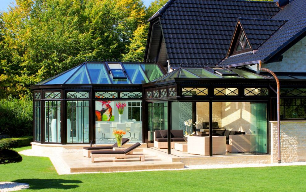Idee per una grande veranda vittoriana con parquet chiaro, camino classico, cornice del camino in legno, lucernario e pavimento marrone