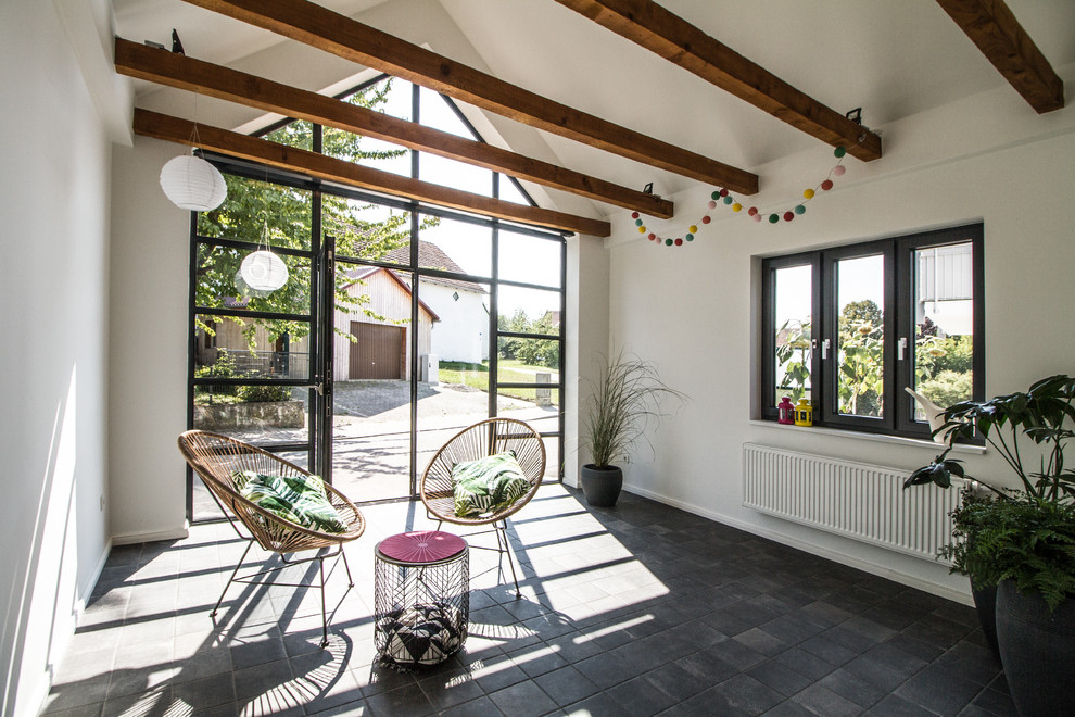 Ispirazione per una veranda design di medie dimensioni con nessun camino, soffitto classico e pavimento nero