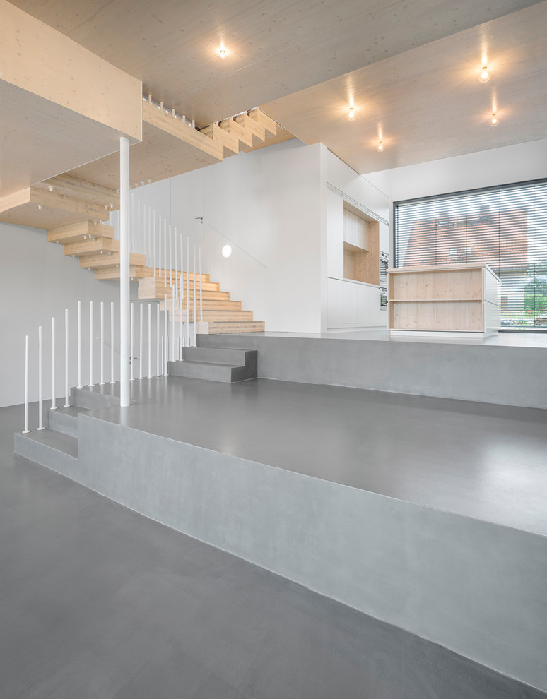 Ejemplo de salón para visitas abierto contemporáneo grande con paredes blancas, suelo de cemento y suelo gris