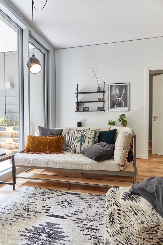 Kleines, Abgetrenntes Modernes Wohnzimmer ohne Kamin mit grauer Wandfarbe, braunem Holzboden und braunem Boden in München