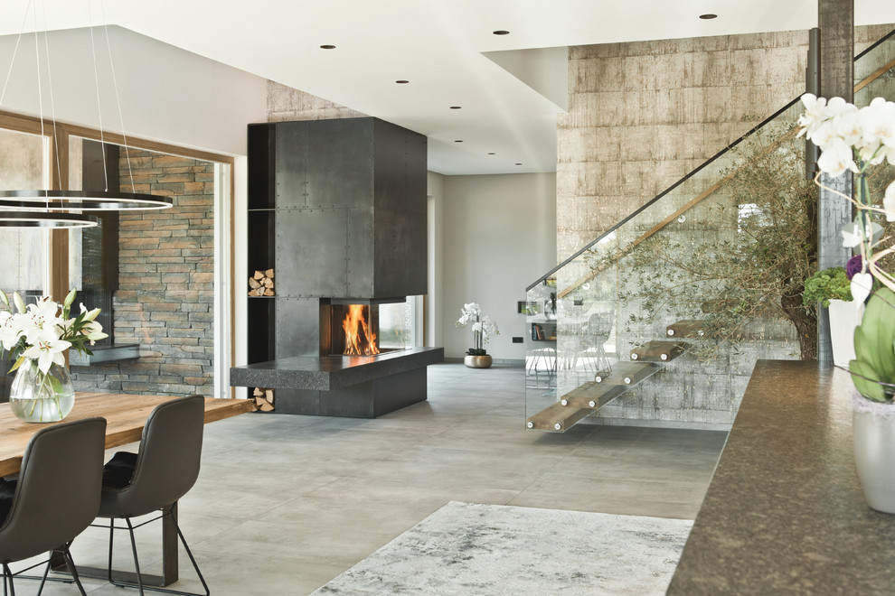 Inspiration for a huge contemporary formal and open concept limestone floor and beige floor living room remodel in Munich with a wood stove, a metal fireplace, beige walls and no tv
