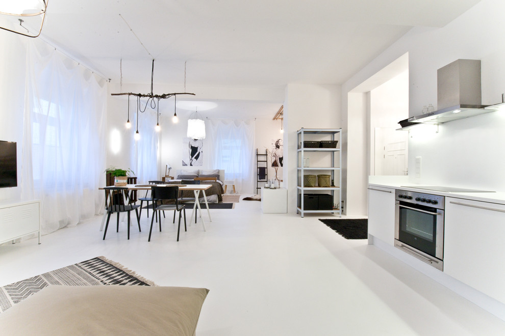 Стильный дизайн: парадная, двухуровневая гостиная комната среднего размера в скандинавском стиле с белыми стенами, бетонным полом и телевизором на стене - последний тренд