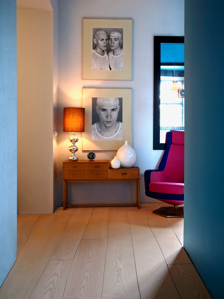 Modelo de salón ecléctico pequeño con paredes azules y suelo de madera clara
