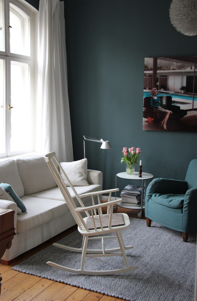 Cette photo montre une salle de séjour éclectique avec un mur bleu et parquet clair.