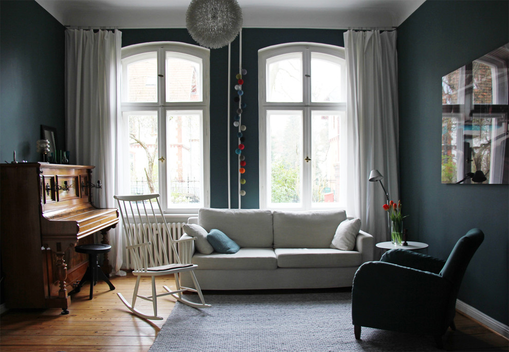 Stilmix Wohnzimmer mit blauer Wandfarbe und hellem Holzboden in Berlin