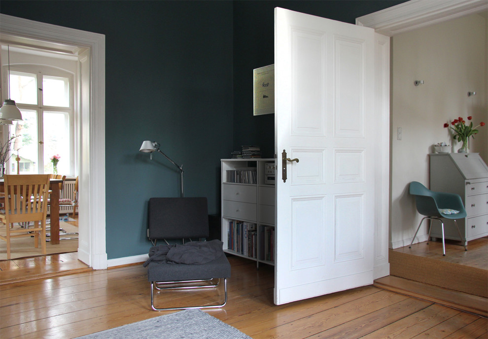 Cette image montre une salle de séjour bohème avec un mur bleu et parquet clair.