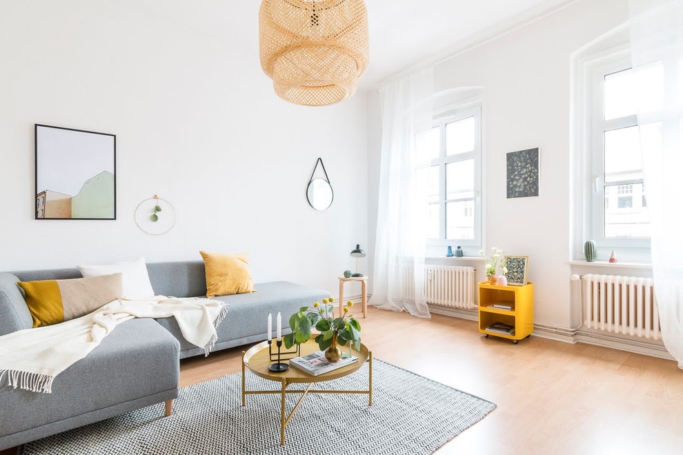 Photo of a medium sized scandinavian living room in Other with white walls, laminate floors, no tv, beige floors and no fireplace.