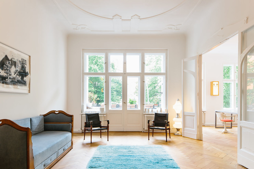 Abgetrenntes Klassisches Wohnzimmer ohne Kamin mit weißer Wandfarbe und hellem Holzboden in Berlin