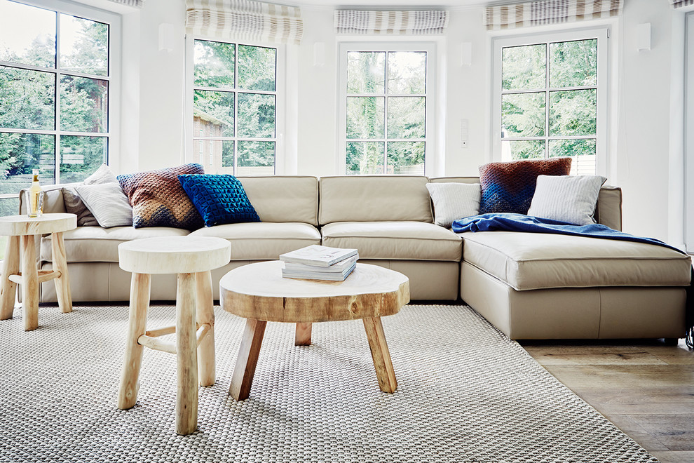 Inspiration for a mid-sized scandinavian light wood floor family room remodel in Other with white walls and no fireplace