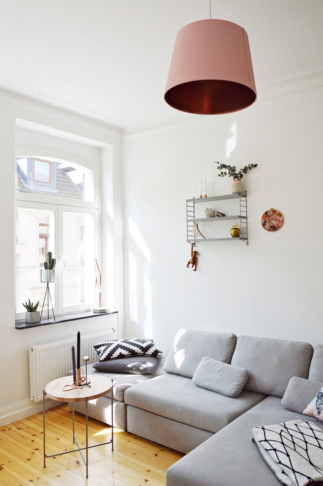 Small danish enclosed light wood floor living room photo in Dusseldorf with white walls