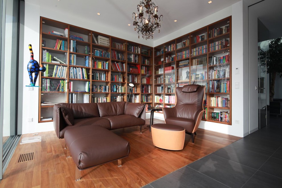 Idéer för mellanstora funkis separata vardagsrum, med ett bibliotek, vita väggar och mellanmörkt trägolv