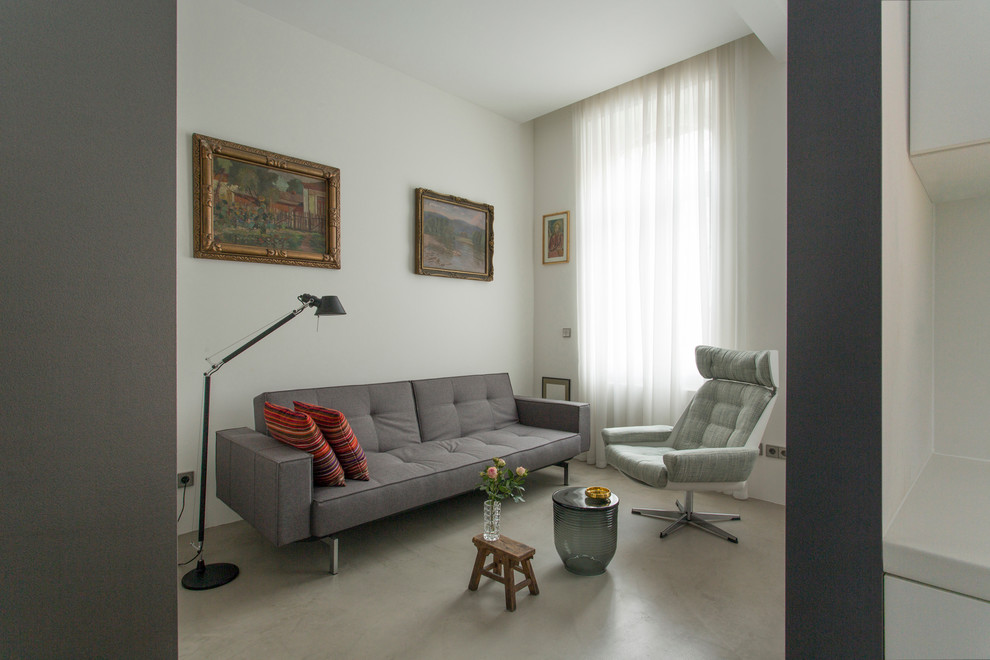 Идея дизайна: маленькая открытая гостиная комната в современном стиле с серыми стенами и бетонным полом без камина, телевизора для на участке и в саду