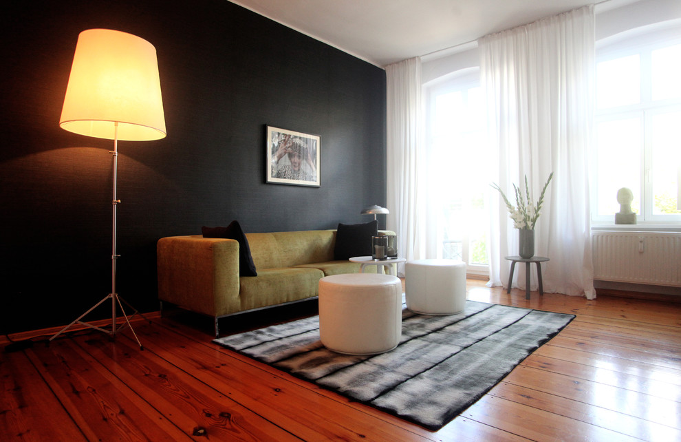 Foto på ett stort 50 tals separat vardagsrum, med svarta väggar och ljust trägolv