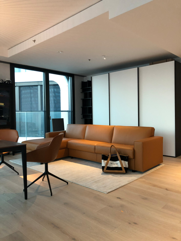 Aménagement d'un petit salon moderne ouvert avec un mur blanc, parquet clair, un téléviseur indépendant et un sol beige.