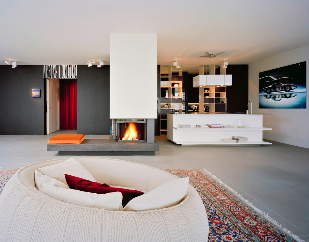 Immagine di un grande soggiorno minimal aperto con pareti nere, camino classico e tappeto