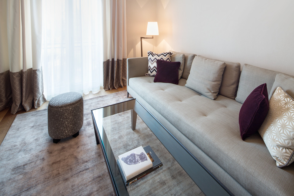 Imagen de sala de estar con biblioteca cerrada contemporánea de tamaño medio sin chimenea y televisor con paredes beige, suelo de madera pintada y suelo beige