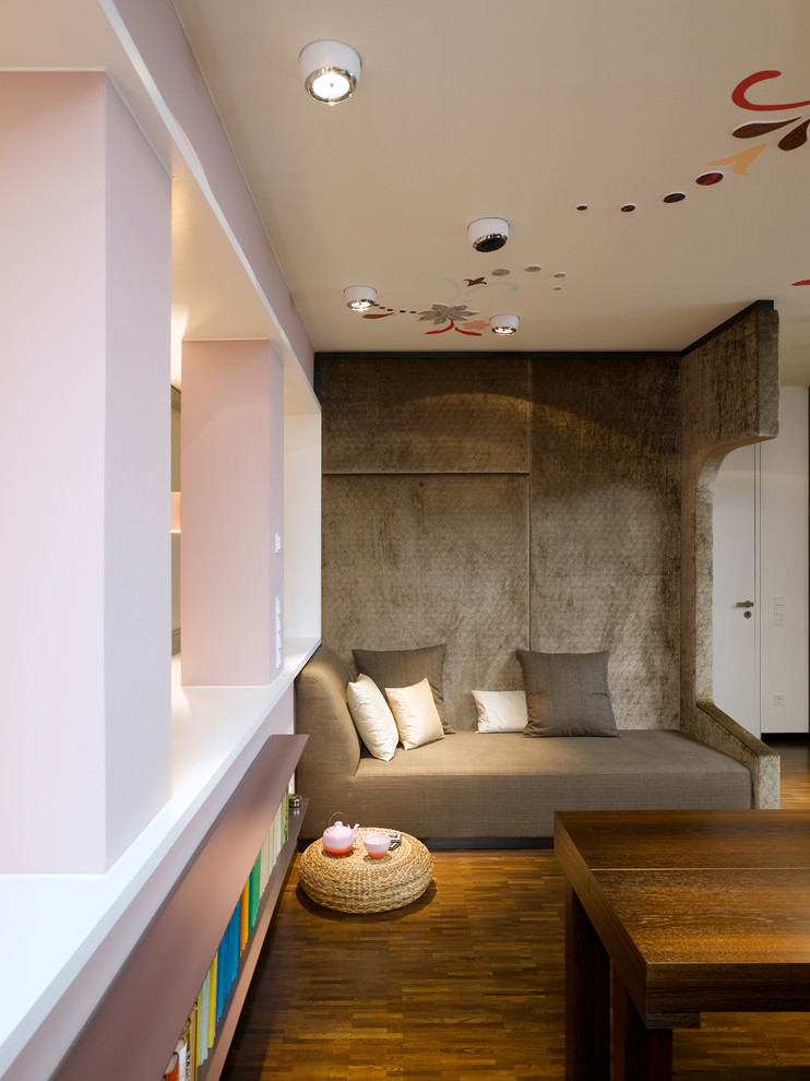 Imagen de salón abierto contemporáneo pequeño con paredes rosas y suelo de madera oscura