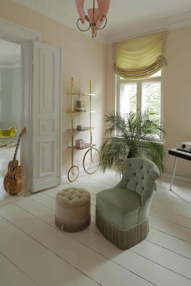 Abgetrenntes Shabby-Style Wohnzimmer mit beiger Wandfarbe und gebeiztem Holzboden in Berlin