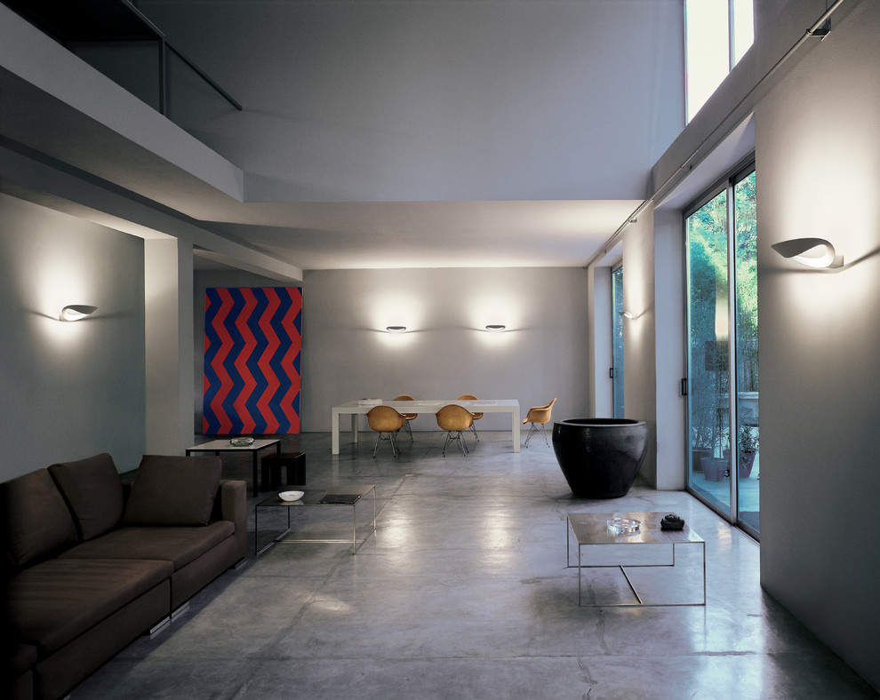Cette image montre un grand salon design ouvert avec une salle de réception, un mur gris, sol en béton ciré et aucune cheminée.