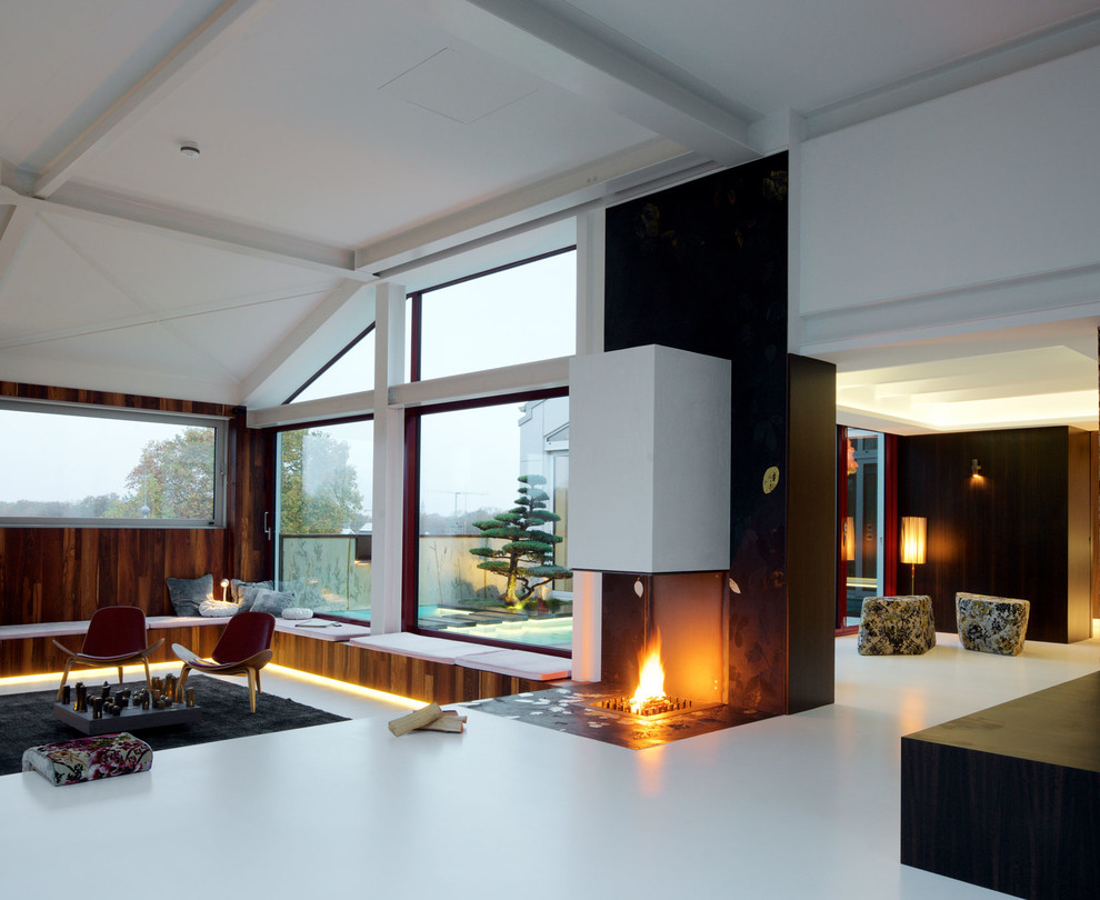 Example of a large zen formal and loft-style concrete floor and white floor living room design in Leipzig with brown walls, a ribbon fireplace, a metal fireplace and no tv
