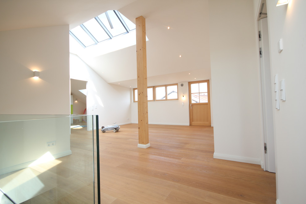 Idéer för ett stort modernt loftrum, med ett finrum, vita väggar, mellanmörkt trägolv, en öppen vedspis, en spiselkrans i gips och beiget golv