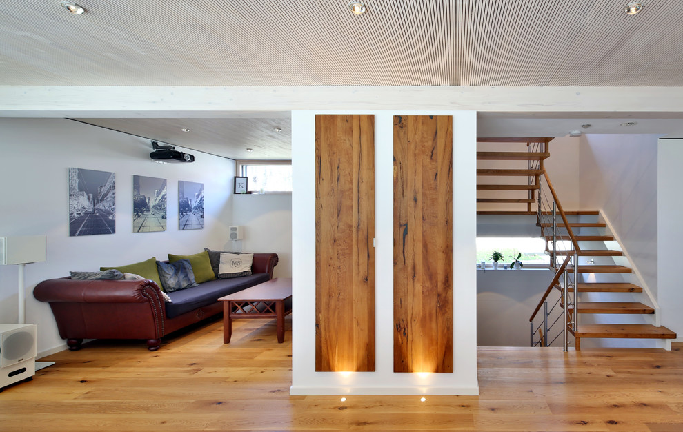 Modelo de salón para visitas abierto actual pequeño sin chimenea con paredes blancas, suelo de madera en tonos medios y suelo marrón