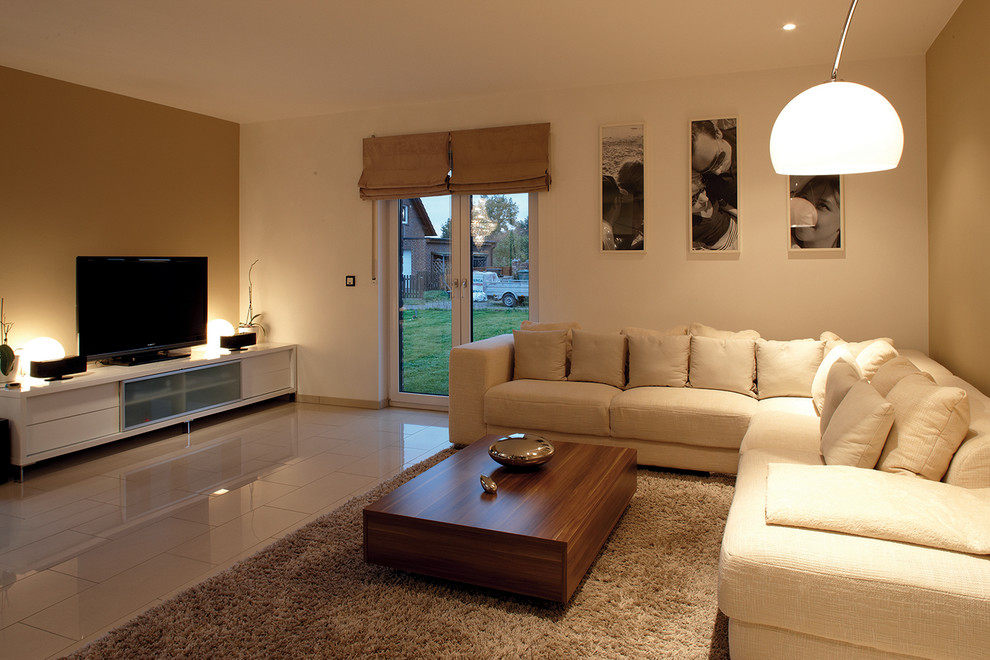 Modernes Wohnzimmer ohne Kamin mit weißer Wandfarbe, freistehendem TV und weißem Boden in Sonstige